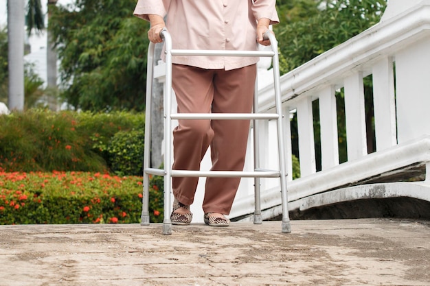 Senior woman with walker in park.