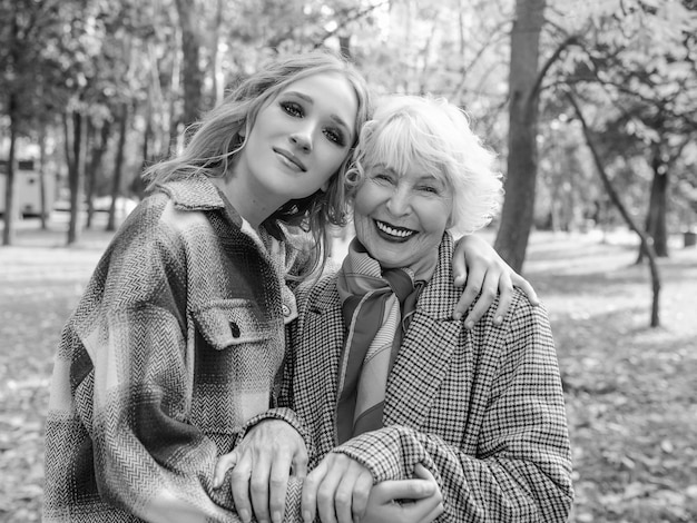 senior woman with young daughter walking outdoorfamily generation care love vaccination concept