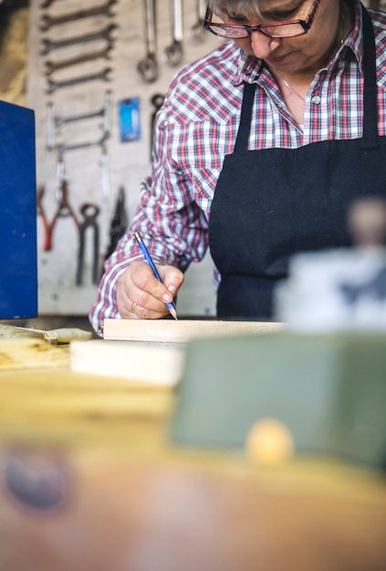 Senior woman working in a carpentry workshop