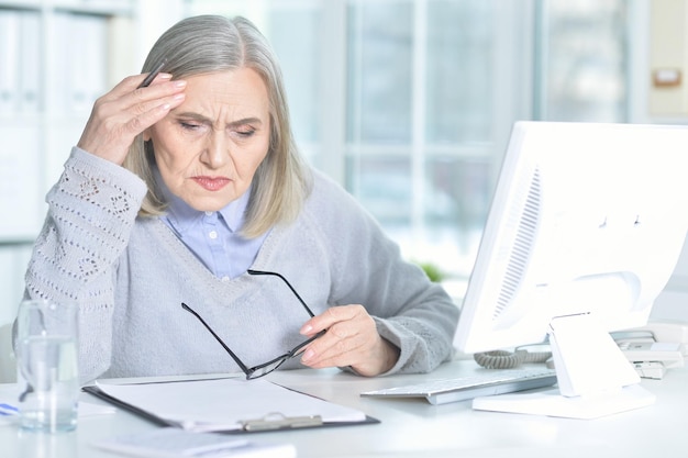 Senior woman working at table with computer