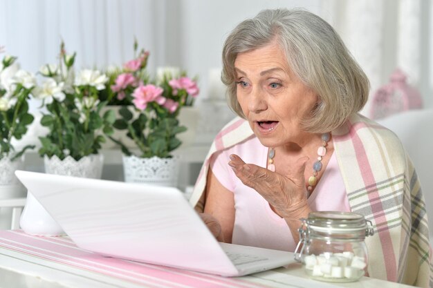 Foto donna anziana che lavora con il laptop a casa