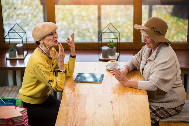 写真 年配の女性とカフェテーブル