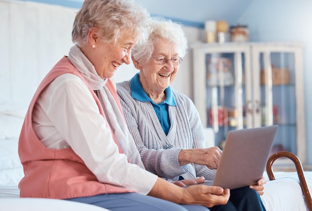 Пожилые женщины-друзья и ноутбук дома для просмотра фильмов в социальных сетях или видеозвонков Технический компьютер и счастливые пожилые пенсионеры смотрят потоковое видео или просматривают Интернет во время разговора вместе