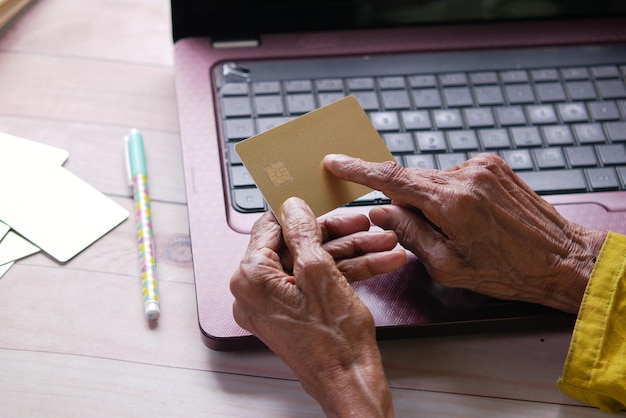 Senior women hand holding credit card white sited