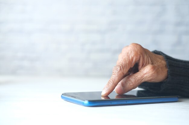 Senior women hand using smart phone close up