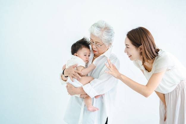 아기를 안고 있는 시니어 여성과 지켜보는 여성