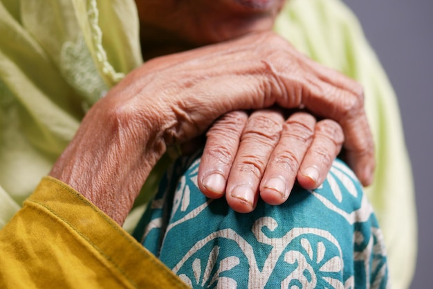 Senior women touching her hand while sited