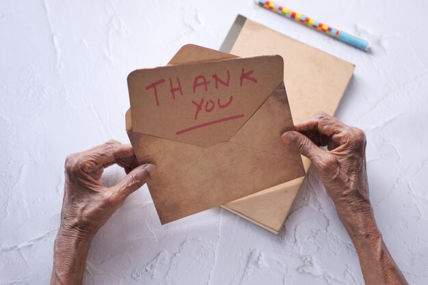 Senior women39s hand met bedankbrief achteraanzicht