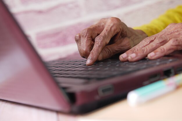 senior womens hand typing on laptop