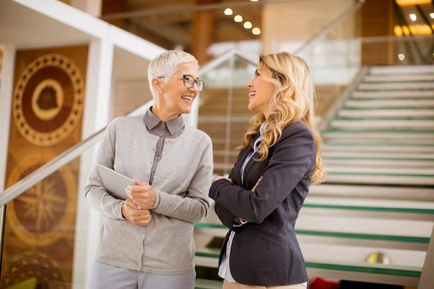 Старшие и молодые деловые женщины спускаются по лестнице