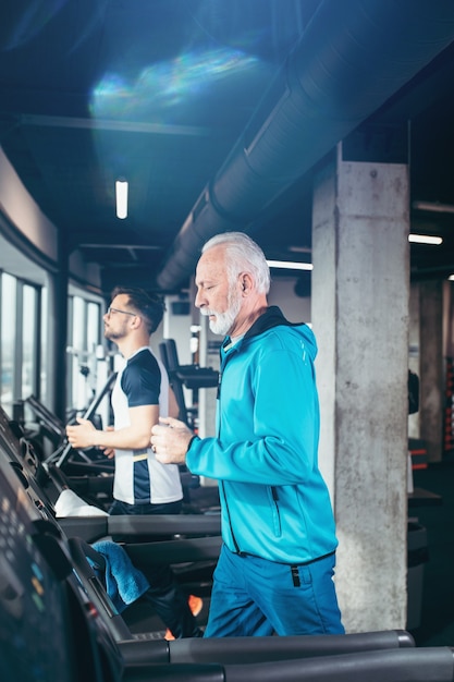 Senior and young sportsmen exercising at gym.