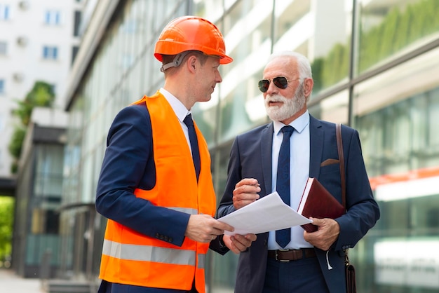 Senior zakenman die aantekeningen maakt Ingenieursman geeft advies aan senior man