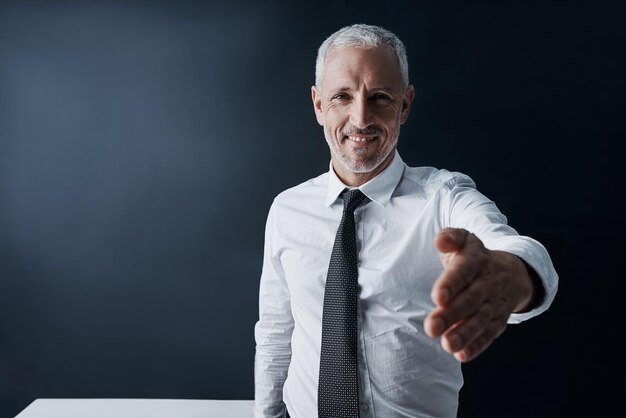 Senior zakenman open handdruk en portret met glimlach voor welkom respect of onboarding op de werkplek Ceo human resources manager en vriendelijkheid voor het inhuren van kansen of partnerschap op kantoor