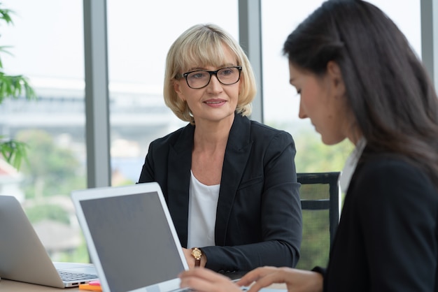 Senior zakenvrouw leider in gesprek met collega's