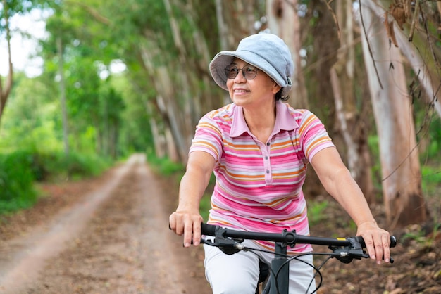 Senior zakenvrouw vrouwelijke rit of fiets mountainbike voor gezonde lichaamsbeweging in het zomerweekend