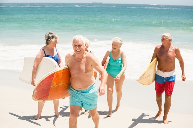 Senioren met surfplanken op het strand