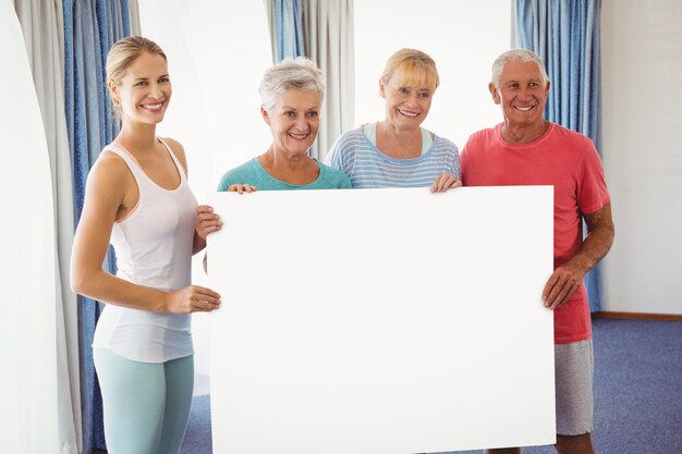 Seniors and fitness instructor holding a blank paper