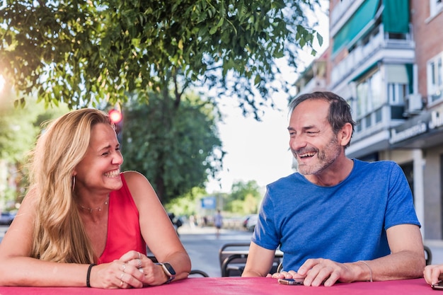 Seniors hispanic couple smiling in outdoors restaurant cheerful dinner in love mid man and woman