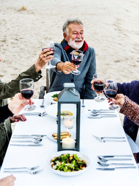 Seniors toasting with red wine at the beach