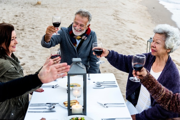 Seniors toasting with red wine at the beach