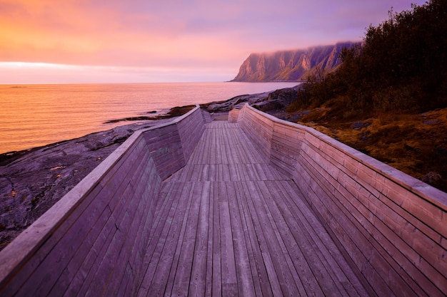 Senja eiland bij zonsondergang licht Houten pad op het rotsachtige strand