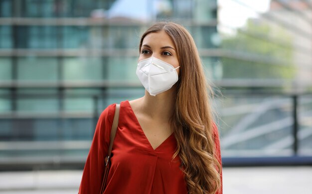 Sense of bewilderment. Young woman in empty city street wearing protective mask.