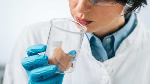 Sensory Analysis of Sea Fish Sample in a Test Tube Food Safety Inspector Smelling Sample in Laboratory