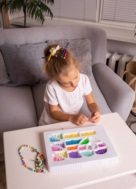 Sensory games with colorful beads with a child at home