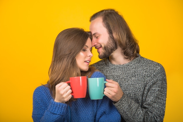 Sensual couple couple in warm sweaters cup with tea hot drink woman in warm sweater holds cup of tea