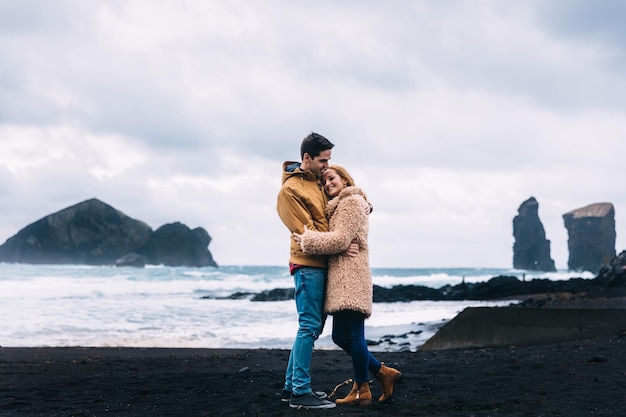 Sensual embrace of a guy and girl on the shore of the ocean