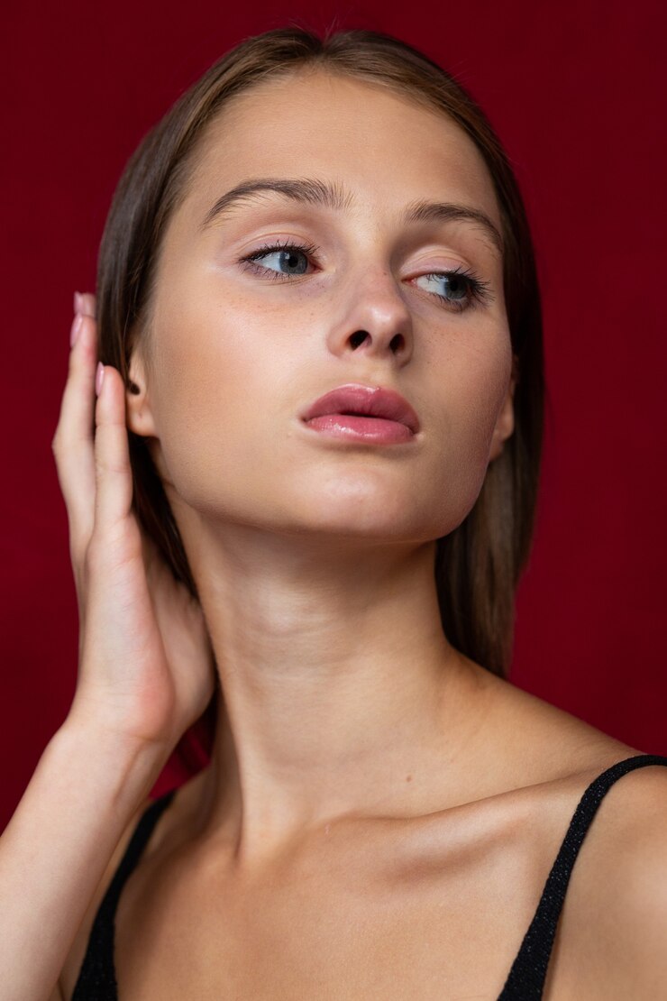 顔の近くに彼女の手で官能的でフェミニンな女性の肖像画。