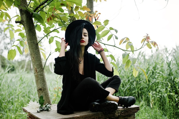 Sensual girl all in black red lips and hat Goth dramatic woman