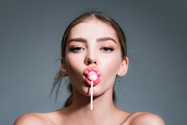 Sensual glamorous attractive lady licking yummy sugary lollypop with red lips girl sucks lollipop fl