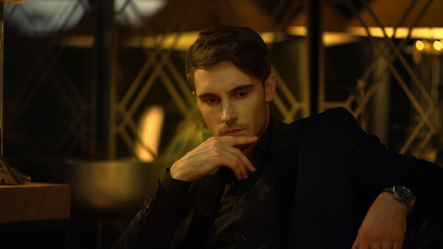 Sensual man looking at someone in front of him Rich guy sitting in armchair