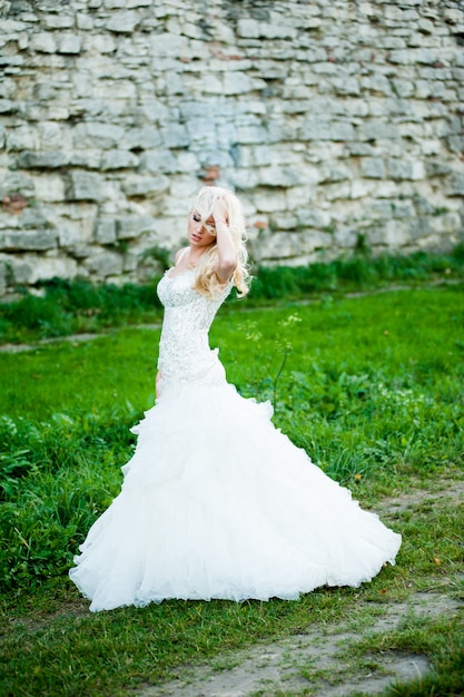 Photo sensual portrait of beautiful bride near old castle before wedding ceremony in church
