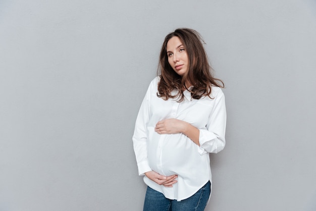 Sensual pregnant woman in studio looking away