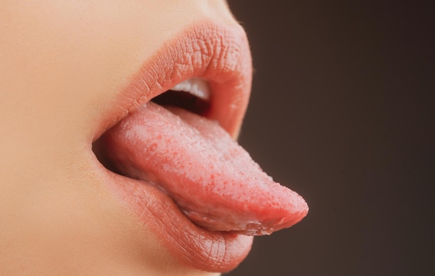관능적 인 매혹적인 입 근접 촬영 여자는 섹시한 혀를 보여줍니다