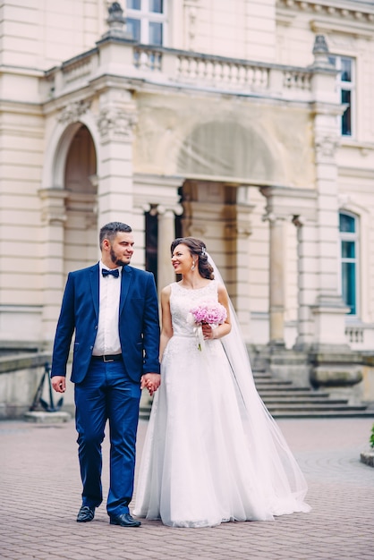 sensual wedding couple walking in the palace yard.