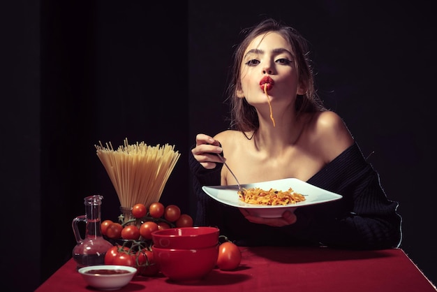 La donna sensuale mangia gli spaghetti la ragazza italiana mangia la pasta degli spaghetti