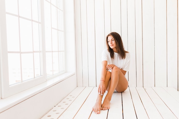 Sensual woman relaxing near window