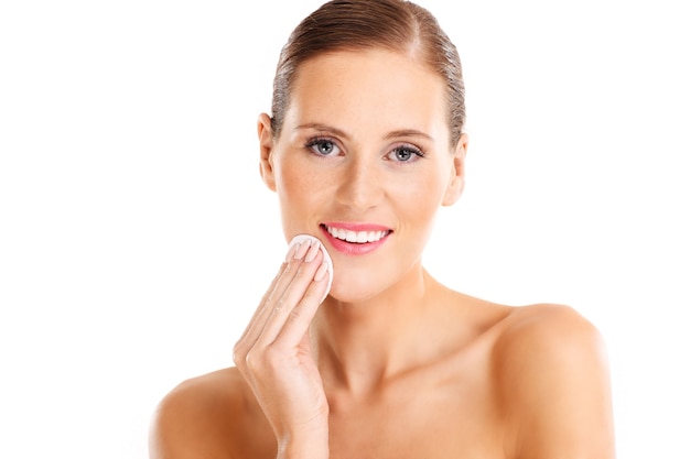 sensual woman removing makeup over white background