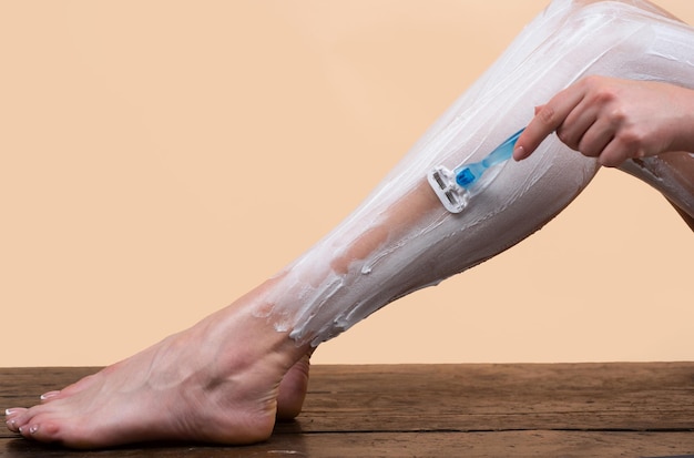 官能的な女性が足を剃る衛生皮膚ボディケアコンセプト脱毛セクシーな女性が足を剃る
