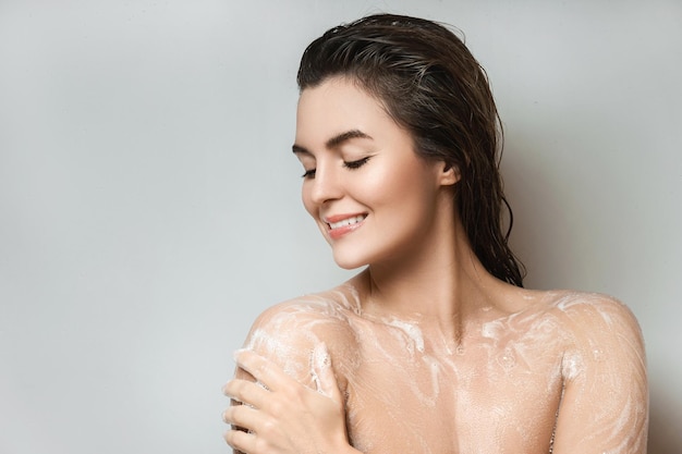 Sensual woman washing her body with shower gel