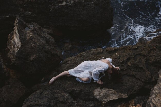 Sensual woman in white wedding dress on sea shore wet hair unaltered