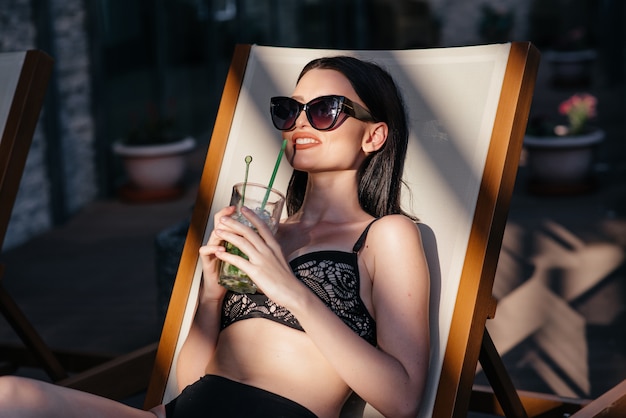 Photo sensual woman with sunglasses drinking a cocktail