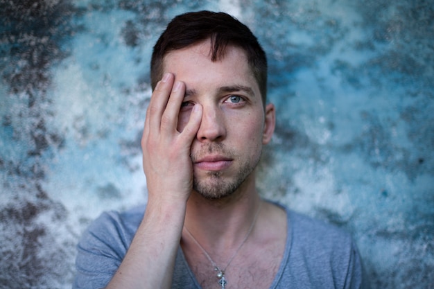 Sensueel portret van een knappe jongeman op een metallic blauwe rug