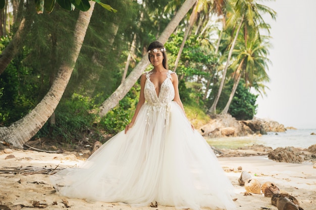 Sensuele bruid die mooie huwelijkskleding op het tropische eiland draagt
