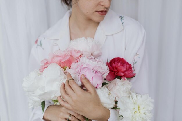 Sensuele mooie vrouw met roze wit pioenboeket in handen Lente-esthetiek Bruidsochtend