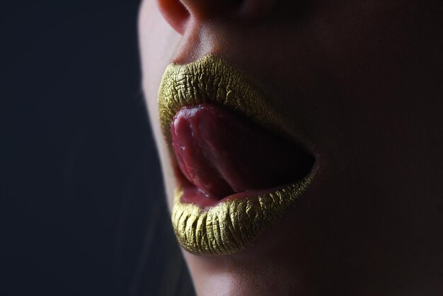 Sensuele tong likken lippen sensuele vrouw mond sexy meisje gouden lippen gouden mond gloeiende gouden huid a