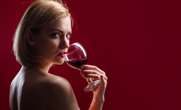 Foto sensuele vrouw drinkt wijn mooi meisje met glas rode wijn alcohol viering verjaardag